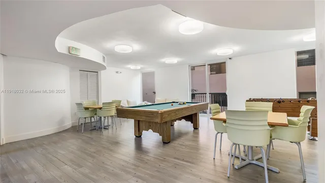 a room with furniture pool table and wooden floor