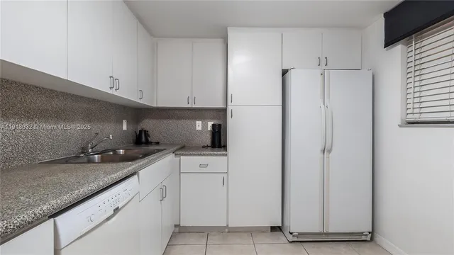 a kitchen with granite countertop cabinets and refrigerator