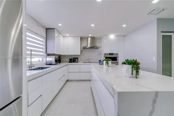 a kitchen with kitchen island sink stove and refrigerator