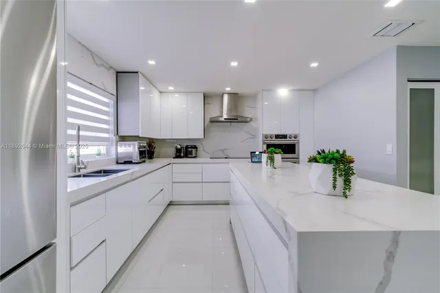 a kitchen with kitchen island sink stove and refrigerator