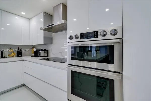 a kitchen with stainless steel appliances granite countertop a stove microwave and sink