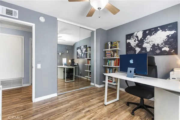 a view of a workspace with furniture and wooden floor