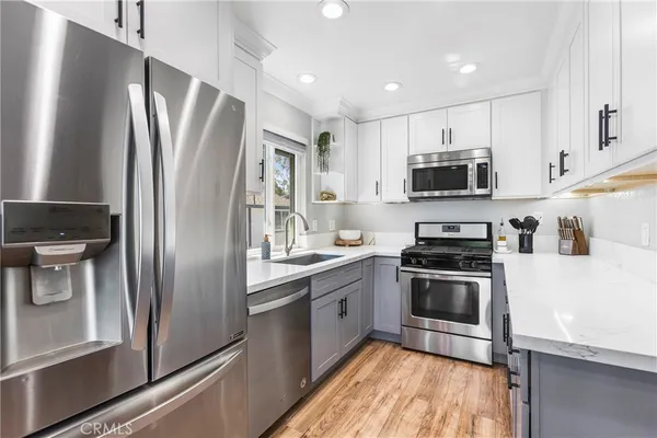 a kitchen with stainless steel appliances a refrigerator sink and microwave