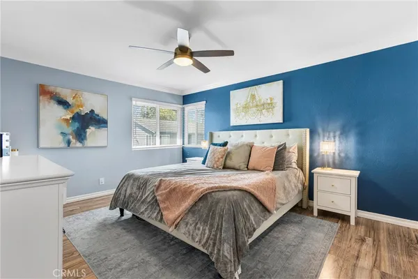 a bedroom with a bed and a painting on the wall