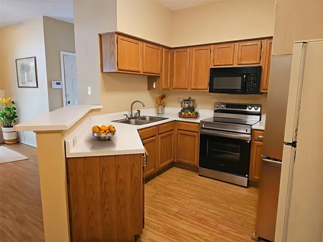 a kitchen with stainless steel appliances a stove a sink and a refrigerator