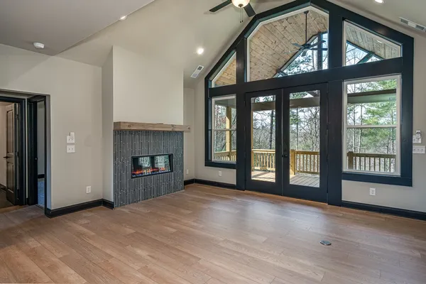 a view of an empty room with a fireplace and a window