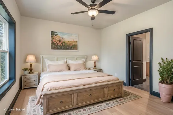 a spacious bedroom with a bed and a potted plant