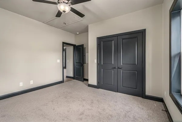 an empty room with closet and a ceiling fan
