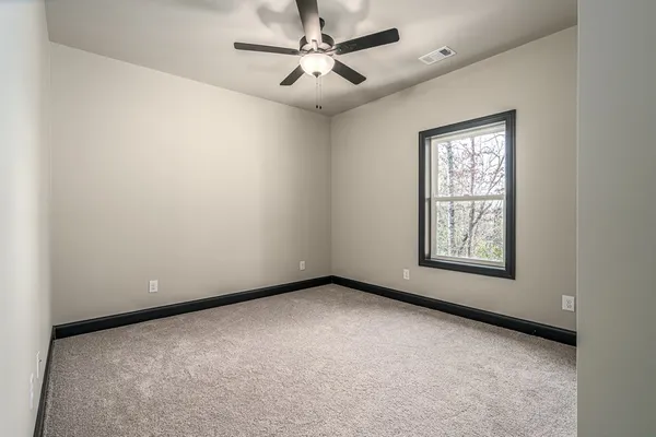 a spacious bedroom with a bed and a potted plant