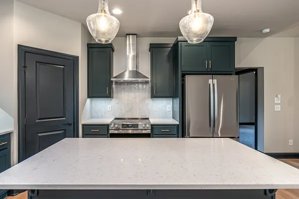 a kitchen with stainless steel appliances a refrigerator and a table