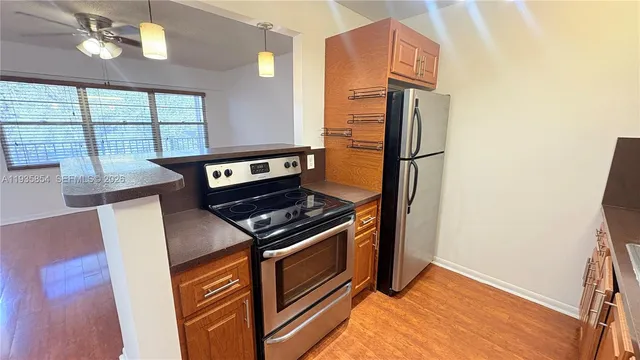 a kitchen with stainless steel appliances granite countertop a stove a refrigerator and a microwave