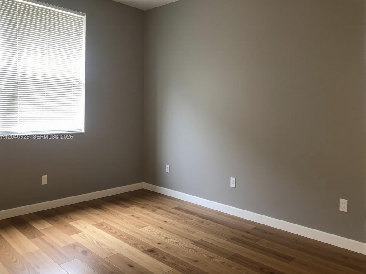 17145 North Bay Road Sunny Isles Beach, FL 33160 - Photo 3 of 6 a view of an empty room with wooden floor and a window