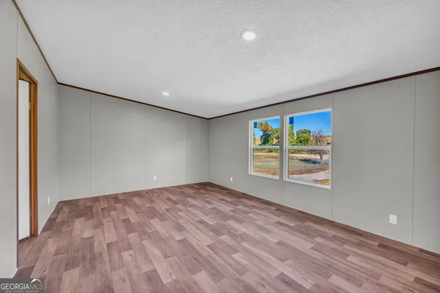 a view of empty room with wooden floor
