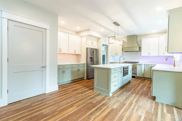 a kitchen with a sink cabinets stainless steel appliances and a window