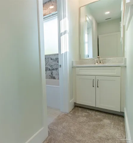 a spacious bathroom with a granite countertop sink and a mirror