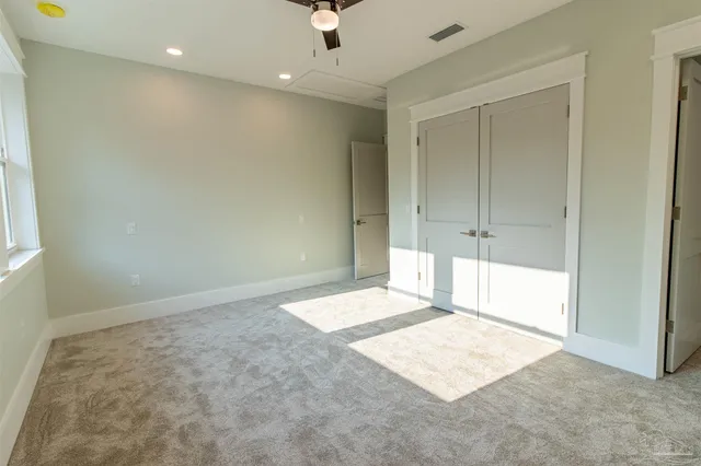 en empty room with windows and ceiling fan