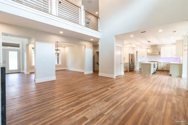a view of an empty room with a fireplace and wooden floor