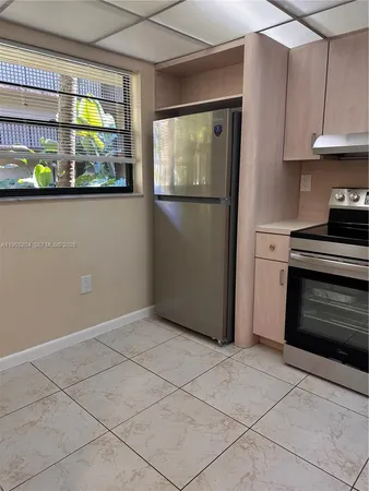a kitchen with stainless steel appliances granite countertop a refrigerator and a stove