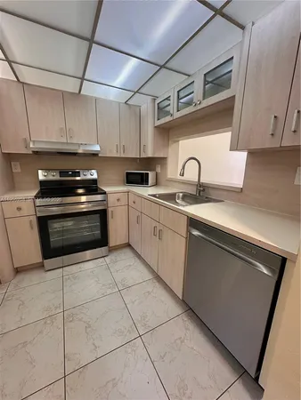 a kitchen with cabinets appliances and a sink
