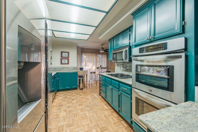 19620 Leadwell Street Reseda, CA 91335 - Photo 9 of 28 a kitchen with stainless steel appliances kitchen island granite countertop a refrigerator a stove and a sink with wooden floor
