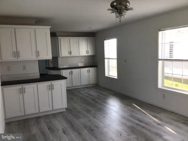 a kitchen with granite countertop white cabinets and window