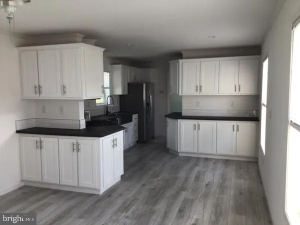 a kitchen with granite countertop white cabinets and stainless steel appliances