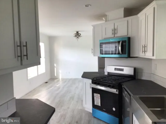 a kitchen with granite countertop a stove and a microwave