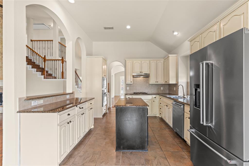 613 Windward Drive Murphy, TX 75094 - Photo 17 of 37 a kitchen with stainless steel appliances granite countertop a refrigerator and a stove