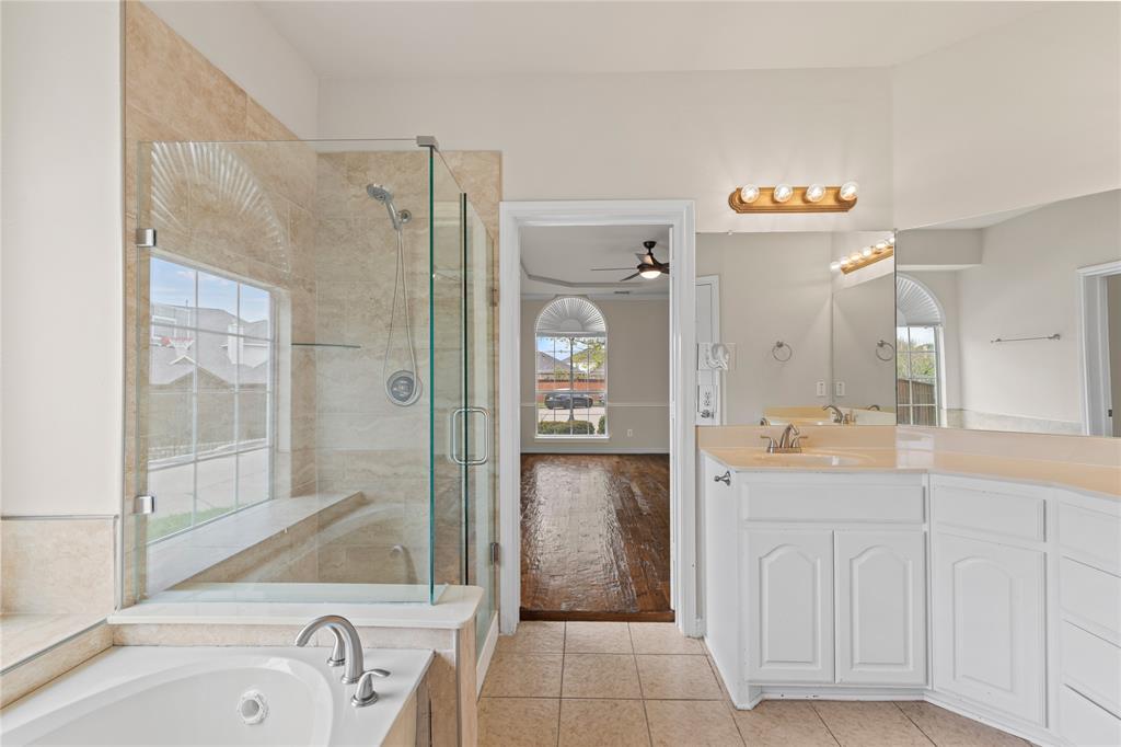 613 Windward Drive Murphy, TX 75094 - Photo 26 of 37 a bathroom with a tub a sink and a large mirror