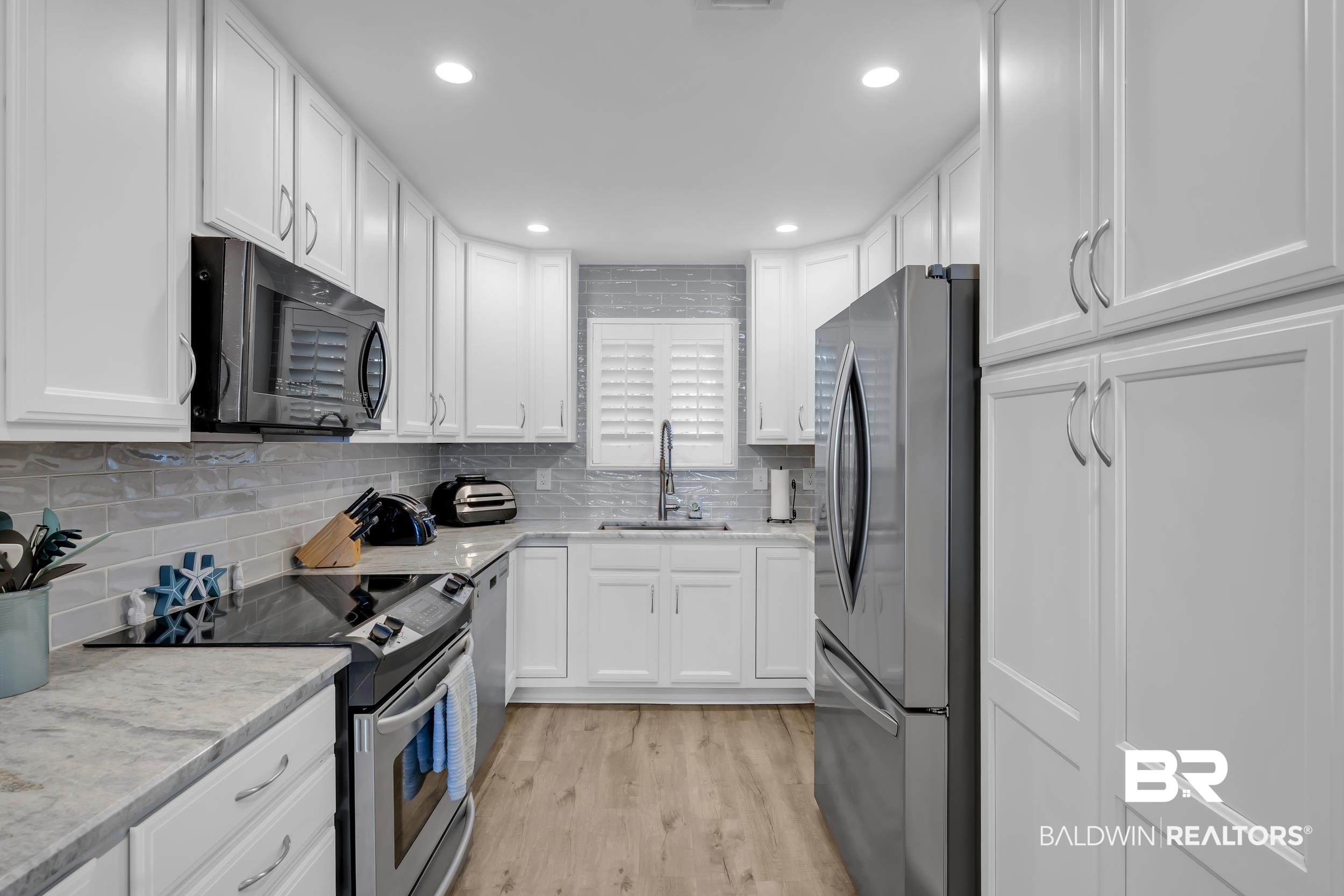 14100 River Road, Unit 211 Pensacola, FL 32507 - Photo 16 of 56 Kitchen featuring white shaker-style cabinetry, recessed lighting, and wood-finish flooring