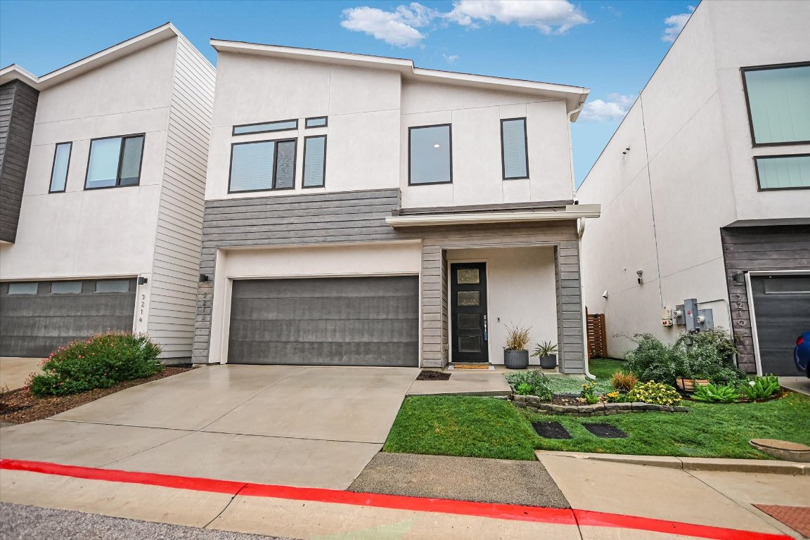 Contemporary house with stucco siding, driveway, and an attached garage