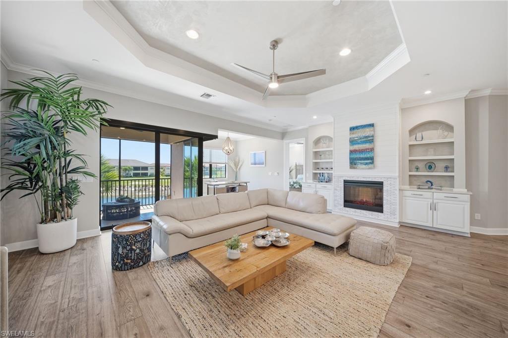 9658 Montelanico Loop, Unit 201 Naples, FL 34119 - Photo 10 of 46 a living room with furniture large window and wooden floor