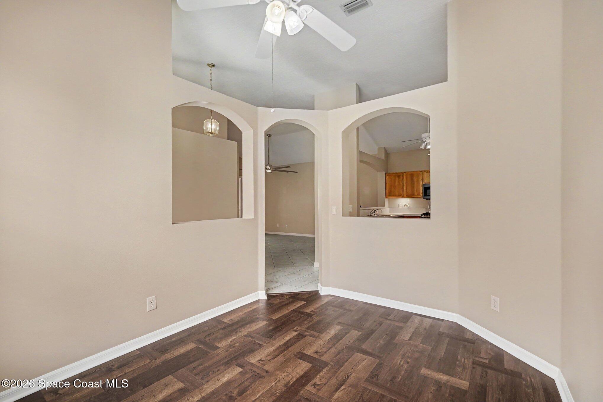 284 Intrepid Way Indialantic, FL 32903 - Photo 9 of 36 an empty room with wooden floor and windows