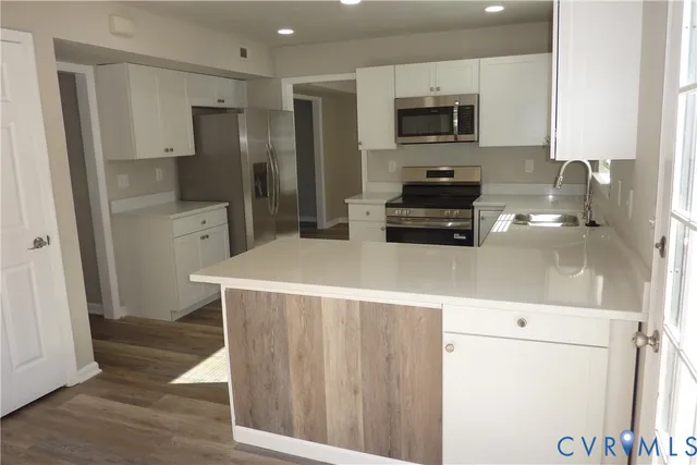 a kitchen with a refrigerator and a stove top oven
