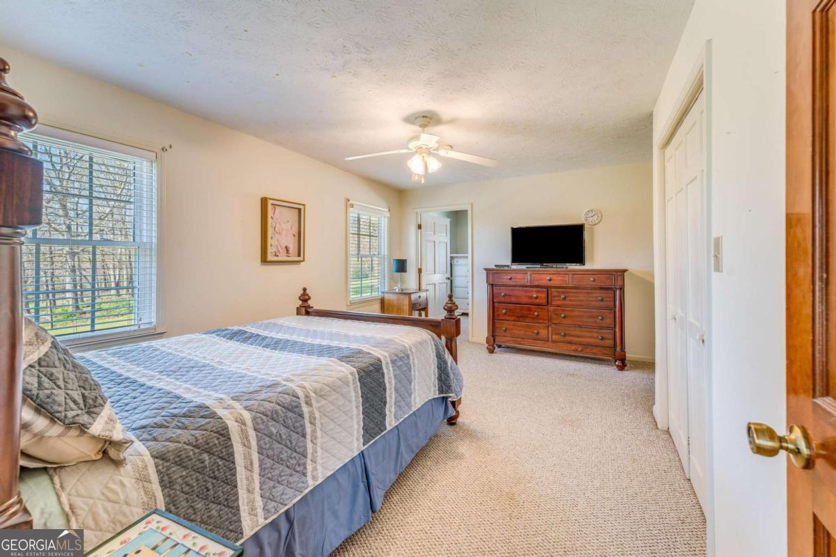 417 Pulliam Lane Royston, GA 30662 - Photo 14 of 27 a spacious bedroom with a bed and a chandelier