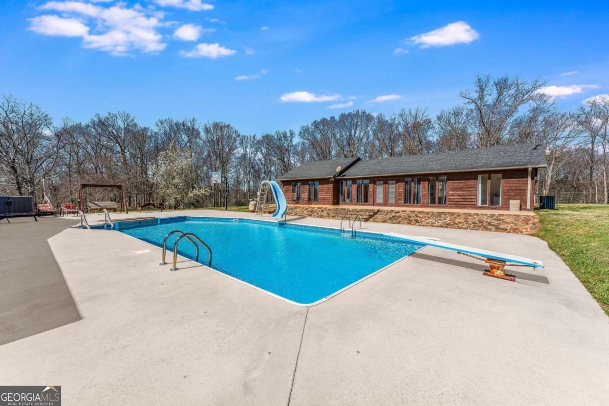 417 Pulliam Lane Royston, GA 30662 - Photo 2 of 27 a view of swimming pool with trees in the background
