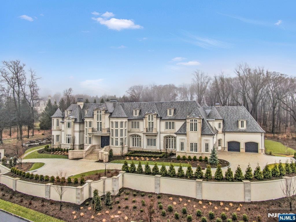 a view of a white house with a big yard and large trees