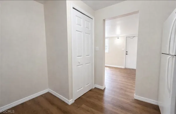 a view of an empty room with wooden floor