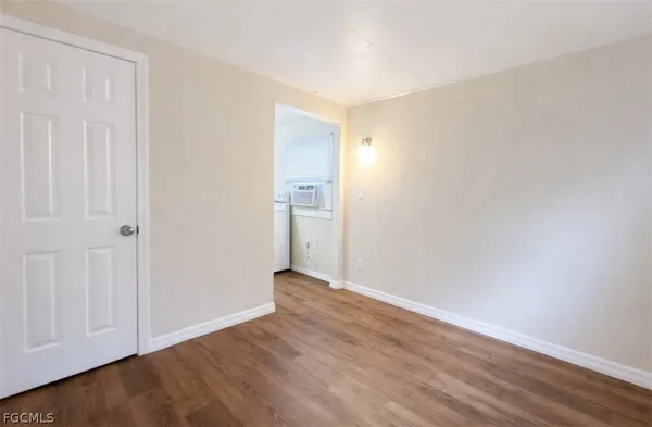 a view of an empty room with wooden floor