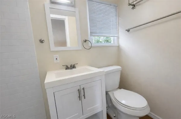 a bathroom with a toilet sink vanity and mirror