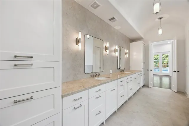 a bathroom with a granite countertop double vanity sink and mirror with bathtub