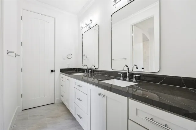 a bathroom with double sink and a mirror