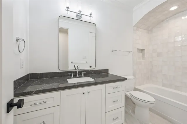 a bathroom with a granite countertop sink a toilet and a mirror