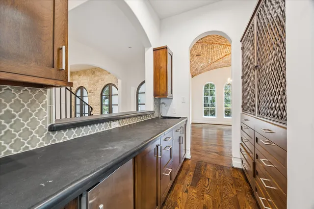 a view of a kitchen with stainless steel appliances granite countertop a stove and a sink
