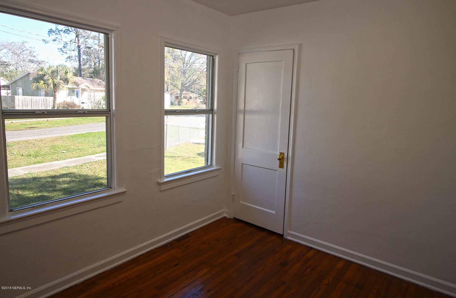 4934 Dundee Road Jacksonville, FL 32210 - Photo 11 of 15 an empty room with wooden floor and windows