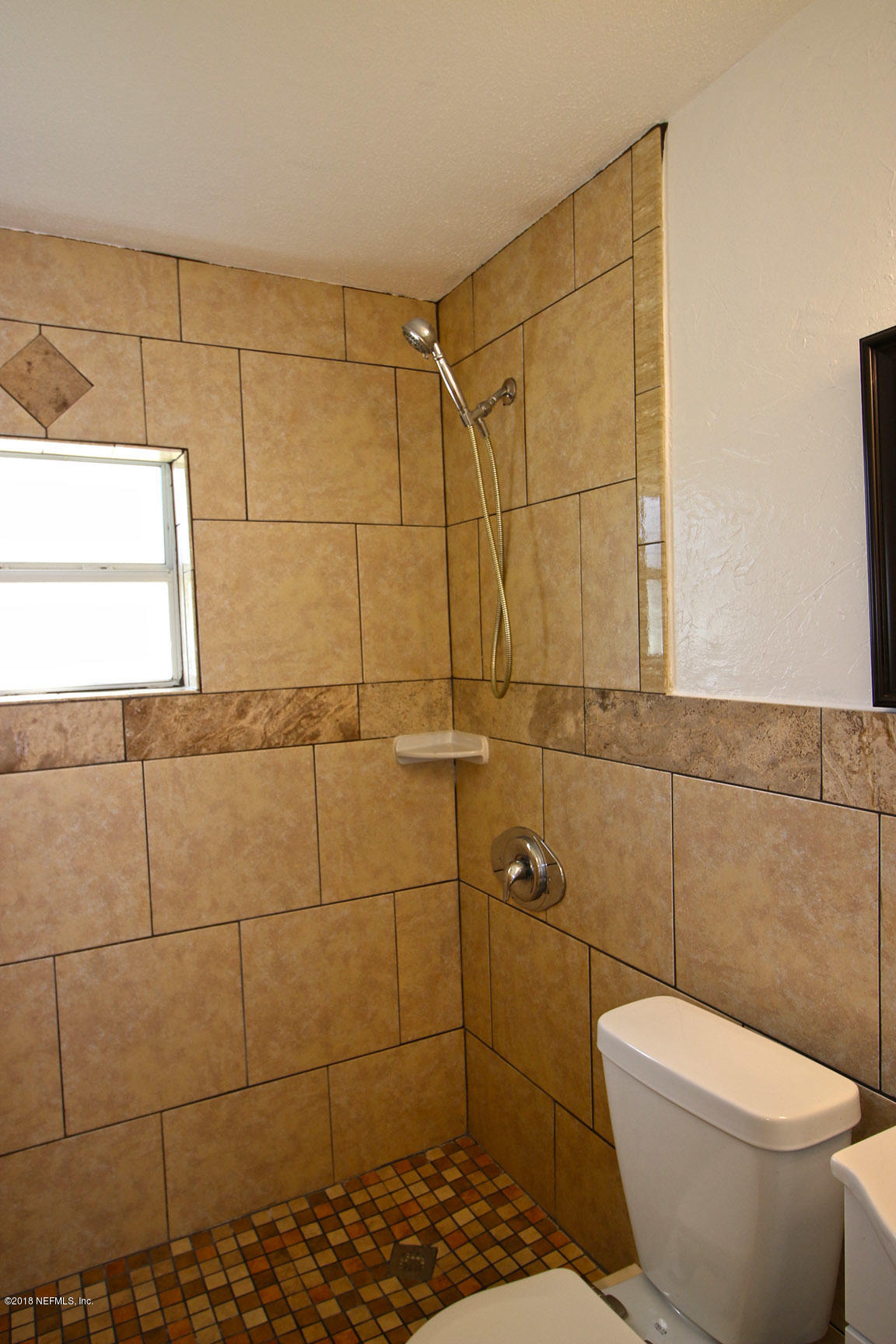 4934 Dundee Road Jacksonville, FL 32210 - Photo 12 of 15 a bathroom with a toilet and a shower