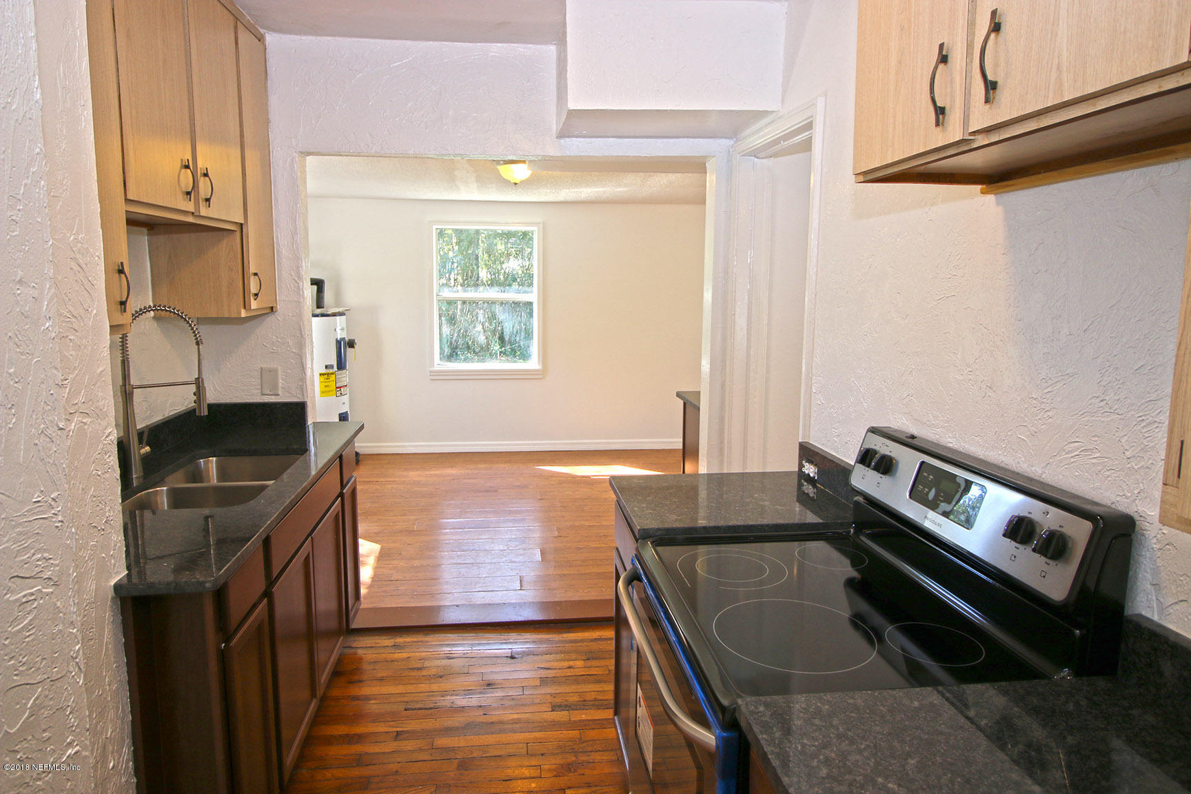 4934 Dundee Road Jacksonville, FL 32210 - Photo 6 of 15 a kitchen with wooden cabinets and a stove top oven