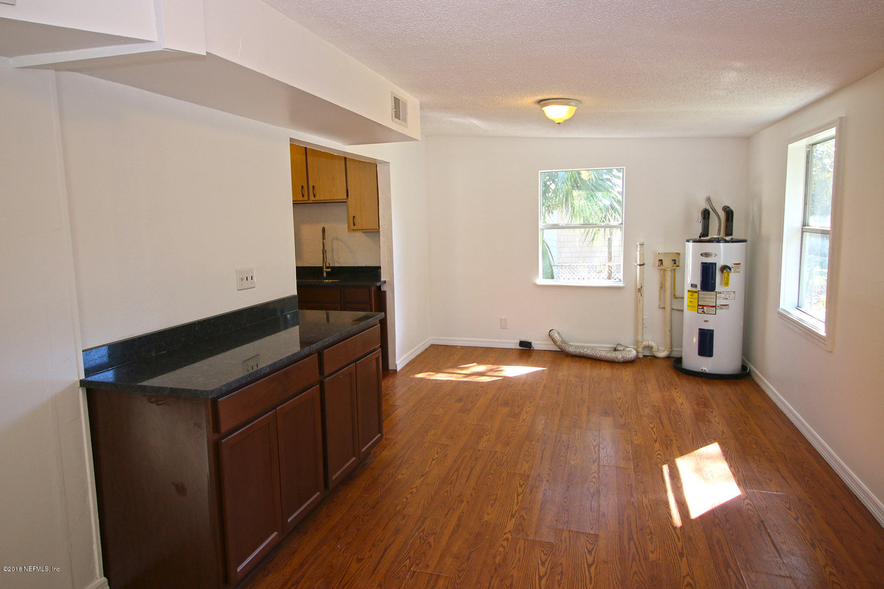 4934 Dundee Road Jacksonville, FL 32210 - Photo 8 of 15 an empty room with wooden floor and windows