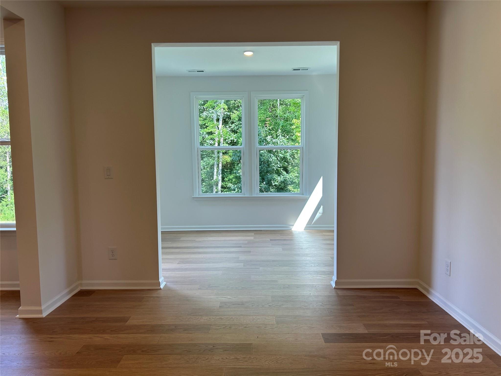 1431 Hubert Graham Way Tega Cay, SC 29708 - Photo 8 of 24 an empty room with wooden floor and windows