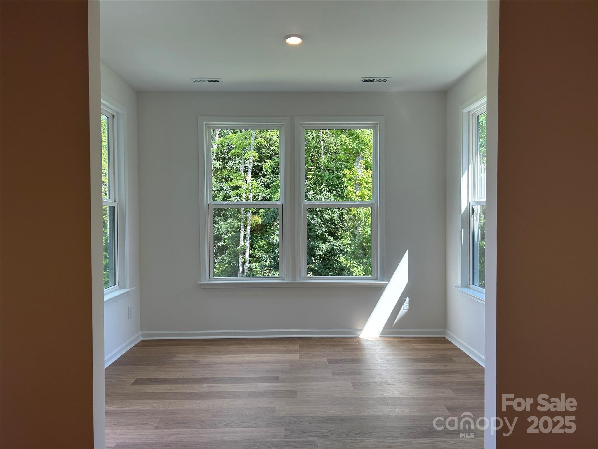 1431 Hubert Graham Way Tega Cay, SC 29708 - Photo 9 of 24 a view of an empty room with wooden floor and a window